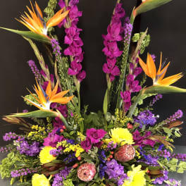 Tropical floral arrangement with orange bird-of-paradise and purple blooms