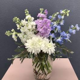 Bouquet of white, pink, and blue flowers in a glass vase