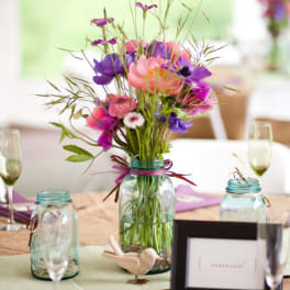 Colorful bouquet in a glass jar centerpiece on a table
