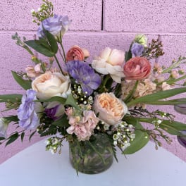 Pastel bouquet of roses, tulips, and lisianthus in a glass vase