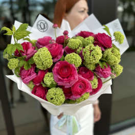 Bouquet of hot pink roses and green pom-pom blooms wrapped in white paper