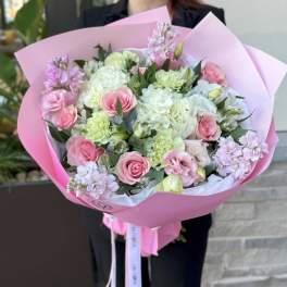 Pink and white bouquet with roses and carnations wrapped in pink paper