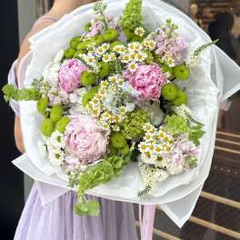 Large bouquet of pink and white flowers with bright green accents wrapped in white paper