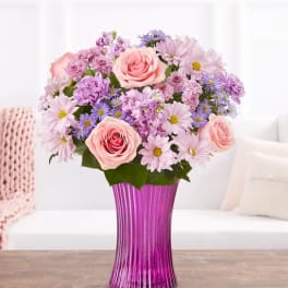 Pink roses and lavender daisies in a purple vase