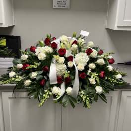 Large red and white funeral spray with roses and lilies