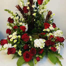 Red roses and white flowers in a large tiered arrangement
