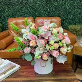 Large pastel bouquet in a white hatbox on a wooden table