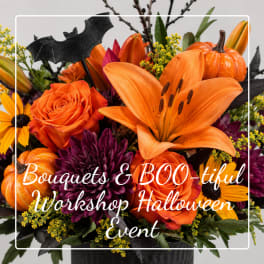 Halloween bouquet with orange lilies, roses, and pumpkins in a black container