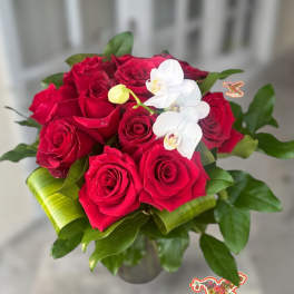 Red roses with white orchids in a glass vase