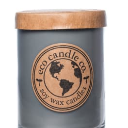 Gray candle in a glass jar with a wooden lid and round label