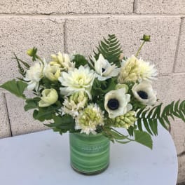 White flowers arranged in a green glass vase