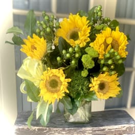 Bouquet of yellow sunflowers in a clear glass vase