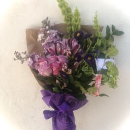 Bouquet of pink and purple flowers wrapped in purple paper