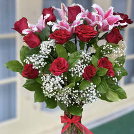 Bouquet of red roses and pink lilies in a glass vase