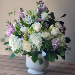White and lavender floral arrangement in a white vase