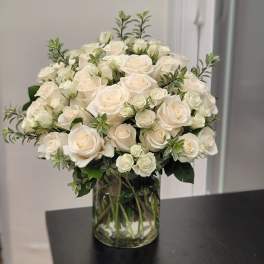 Cream roses arranged in a clear glass vase