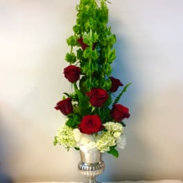 Tall red rose arrangement in a silver urn with white hydrangeas