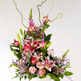 Tall pink and white floral arrangement in a white vase