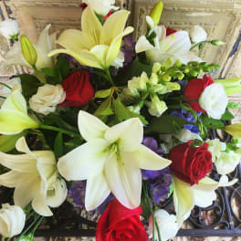 Bouquet of white lilies and red roses with purple accents