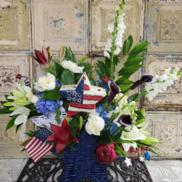 Patriotic floral arrangement in a star-shaped basket with an American flag