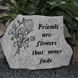 Decorative stone plaque with flowers and the words Friends are flowers that never fade