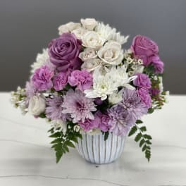 Bouquet of pink, purple, and white flowers in a striped vase