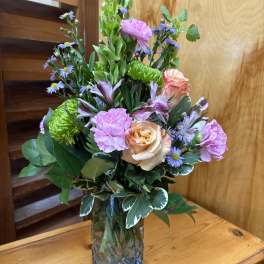 Mixed bouquet in a glass vase with pink and purple flowers