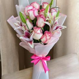 Pink and white rose bouquet with lilies wrapped in pale pink paper