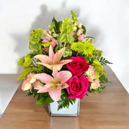 Pink lilies and hot pink roses in a square glass vase