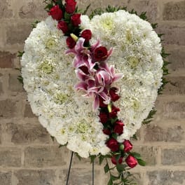 Heart-shaped white floral spray with red roses and pink lilies