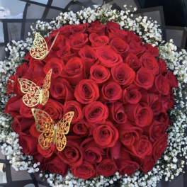 Round bouquet of red roses with white baby's breath and gold butterfly accents