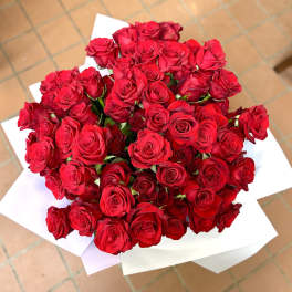 Large bouquet of red roses wrapped in white paper