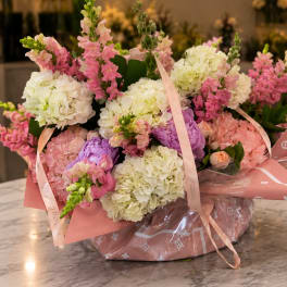 Bouquet of pink and white hydrangeas with snapdragons in pink wrapping