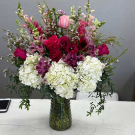 Mixed pink and white floral arrangement in a glass vase