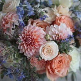 Bouquet of peach and white flowers with blue accents