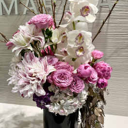 Pink and white floral arrangement in a black vase