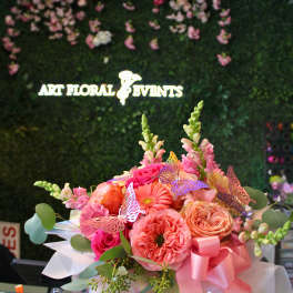 Pink and peach flower bouquet in a white box with a ribbon