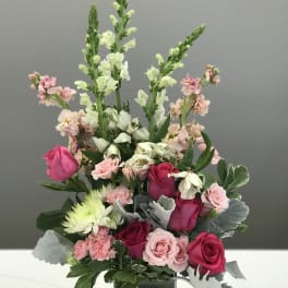 Mixed pink and white flowers arranged in a square vase