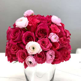 Pink and red rose bouquet in a clear glass vase