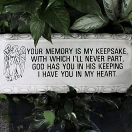 Memorial plaque with an angel and sympathy message surrounded by foliage