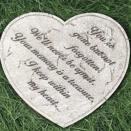 Heart-shaped memorial plaque with an engraved quote on grass