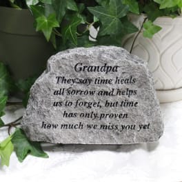 Engraved memorial stone with ivy leaves in the background