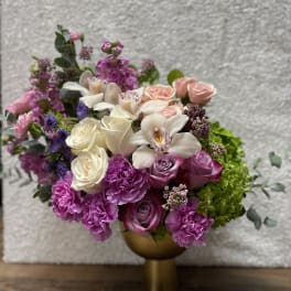 Pink and white floral arrangement in a gold vase
