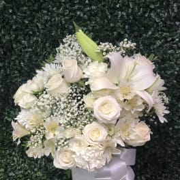 White rose and lily bouquet with baby's breath in a white vase