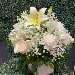 White lily and pale blooms in a white vase