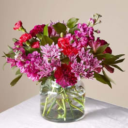 Pink and magenta mixed bouquet in a clear glass vase