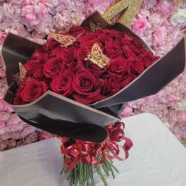 Bouquet of red roses wrapped in black paper with a red ribbon
