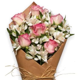 Bouquet of pink roses and white alstroemeria wrapped in brown paper