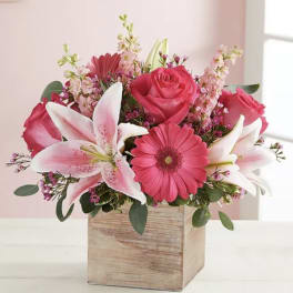 Pink roses, lilies, and gerbera daisies in a wooden box