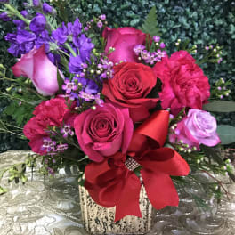 Pink and red rose bouquet with purple flowers in a square vase